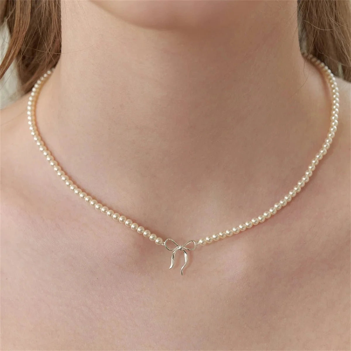 Delikatny kobiecy naszyjnik choker z koralikowymi perłami i kokardką
