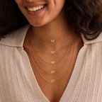 Woman wearing gold necklaces with measurement labels on a beige background