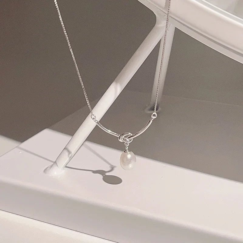 Collana delicata a catena con perla pendente e nodo