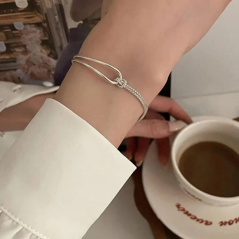 Skręcana bransoletka z okrągłą blaszką i węzłem S925